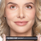 Blonde woman holding the mascara horizontally